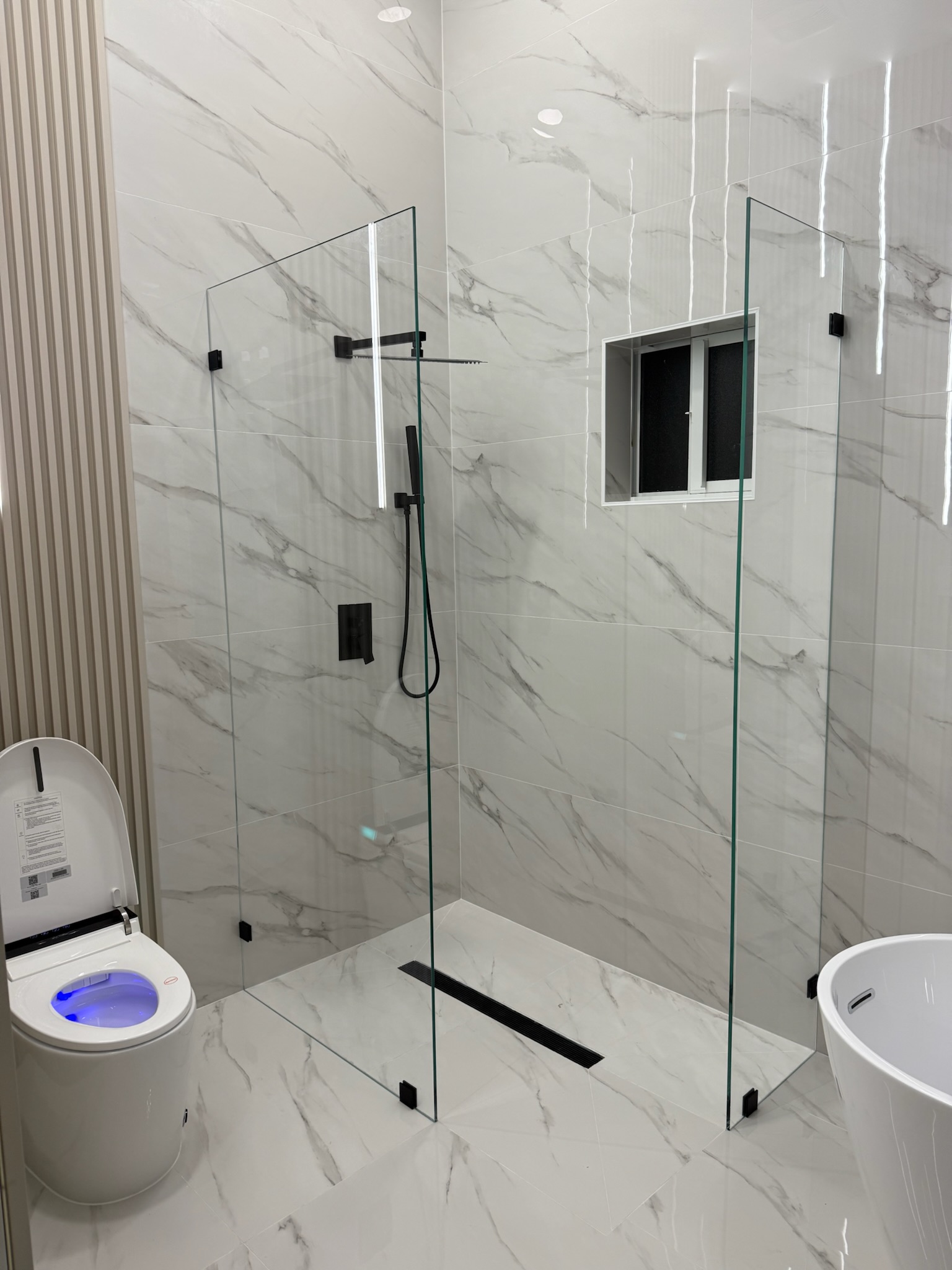 Custom frameless glass shower door in a modern bathroom